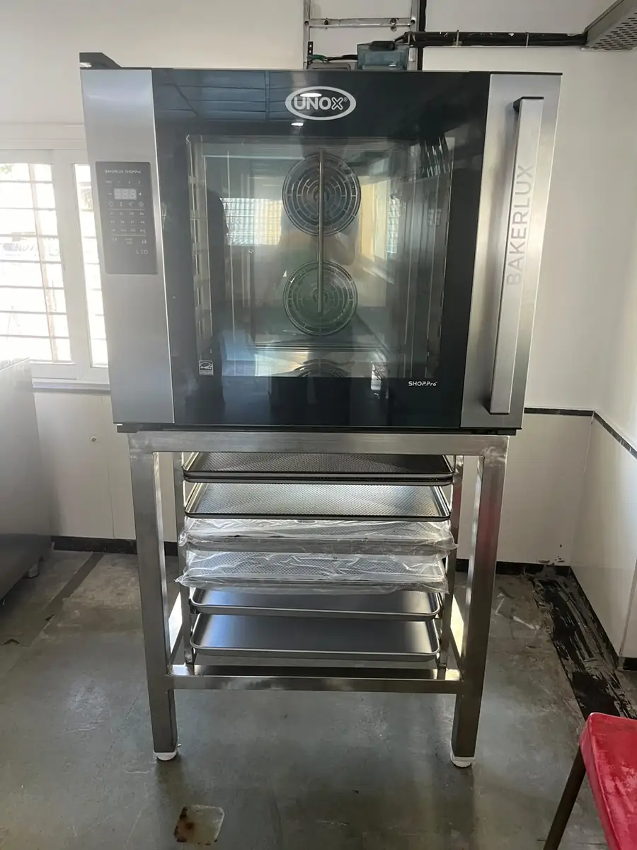 Stainless steel oven stand with tray rack for a food processing kitchen