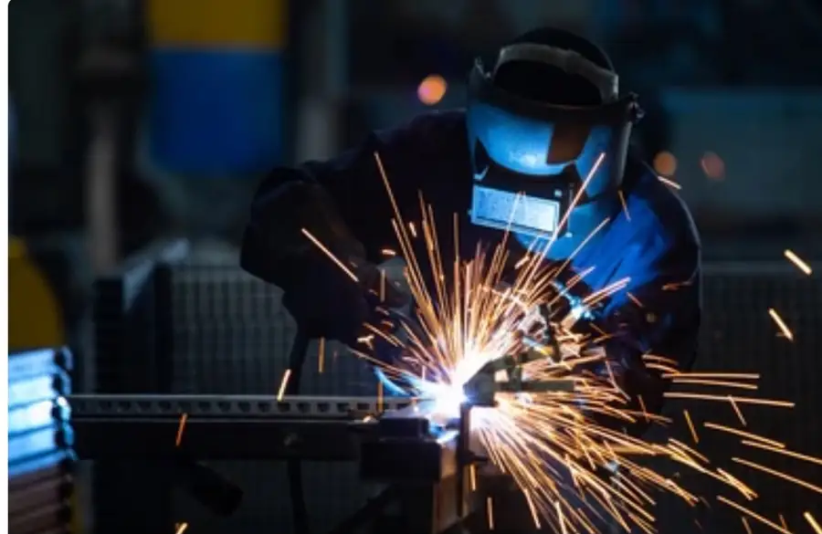 Welder running a MIG weld at the Lalit Industries works, Nashik
