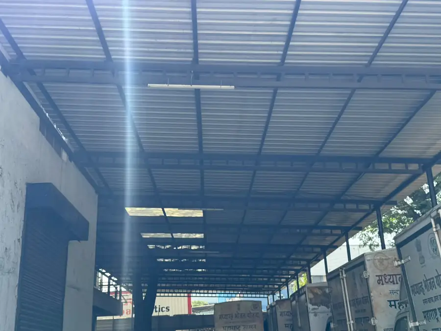 Industrial shed interior with fabricated roof frame and lighting bays